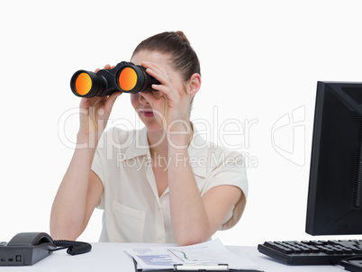 Young businesswoman looking through binoculars