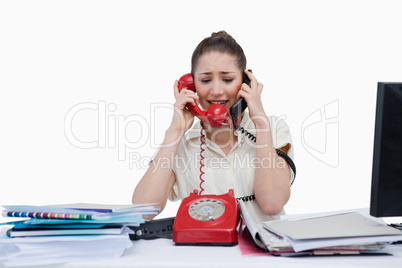 Stressed businesswoman answering the phones