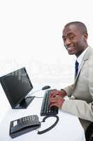 Side view of a smiling businessman using a computer