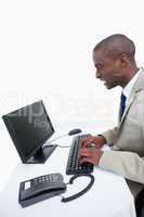 Side view of an angry businessman using a computer