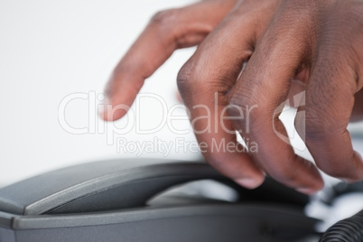 Close up of a masculine hand taking a phone handset