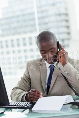 Portrait of an entrepreneur making a phone call while reading a