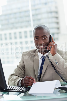 Portrait of a smiling entrepreneur making a phone call while rea