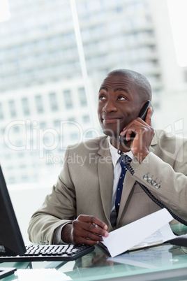 Portrait of a happy entrepreneur making a phone call while readi
