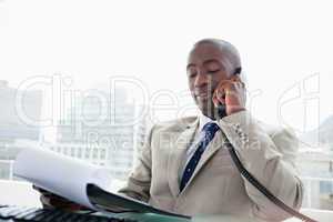 Businessman on the phone while reading a document