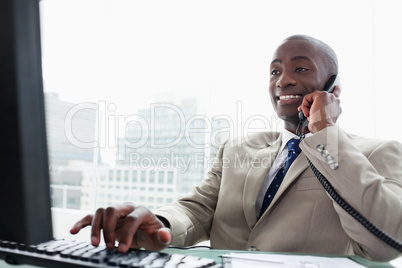 Businessman on the phone while using a computer