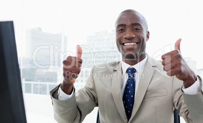 Businessman working with a computer with the thumbs up