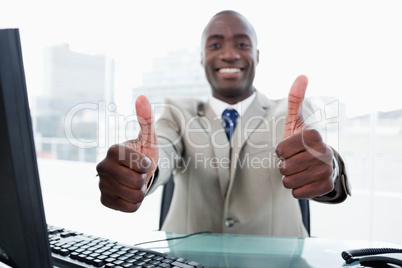 Entrepreneur working with a computer with the thumbs up