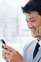 Portrait of a smiling office worker using his mobile phone