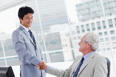 Employee shaking the hand of his manager