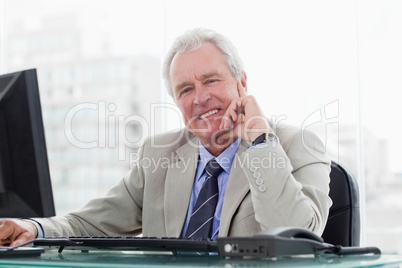 Smiling senior manager working with a monitor