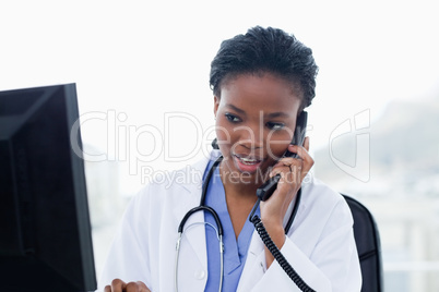 Female doctor on the phone while using a computer