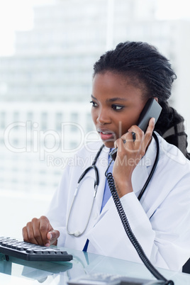 Portrait of a female doctor using a computer while being on the