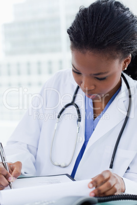 Portrait of a female doctor signing a document