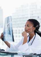 Portrait of a female doctor looking at a set of X-rays