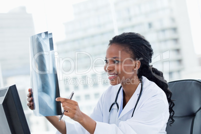 Happy female doctor looking at a set of X-rays