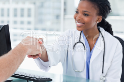 Smiling female doctor shaking a hand