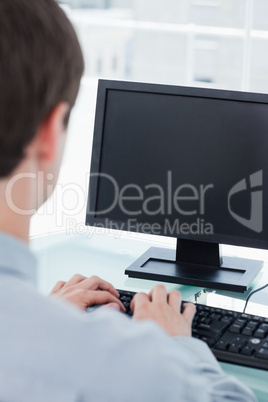 Back view of a businessman using a monitor