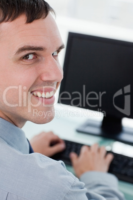Back view of a smiling businessman using a monitor