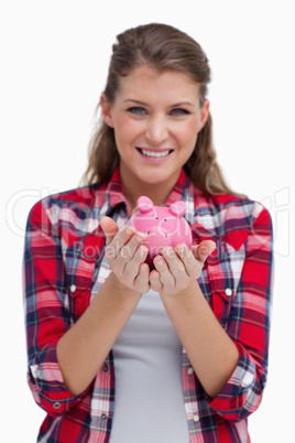 Portrait of a woman holding a piggy bank