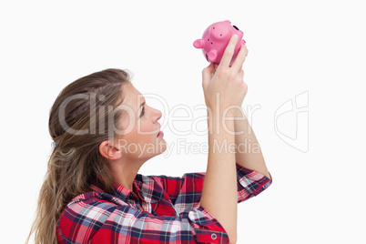 Woman looking inside a piggy bank