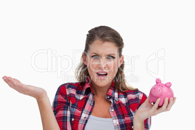 Broke woman holding a piggy bank