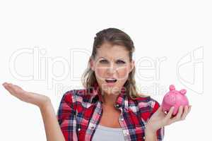 Broke woman holding a piggy bank