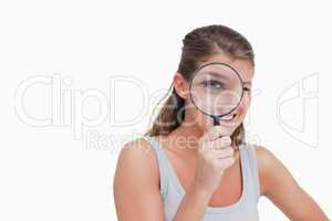 Woman looking through a magnifying glass