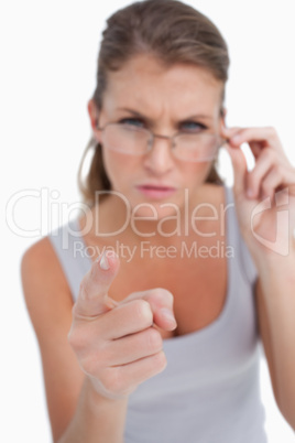 Portrait of an angry woman with glasses pointing at the viewer