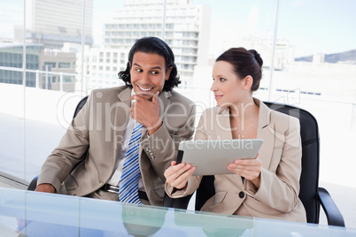 Smiling business team using a tablet computer Smiling business team using a tablet computer