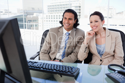 Smiling business team using a computer