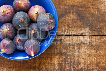 Bowl of ripe figs on rustic wooden table