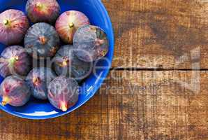 Bowl of ripe figs on rustic wooden table