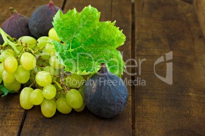 Figs and grapes on old wooden table