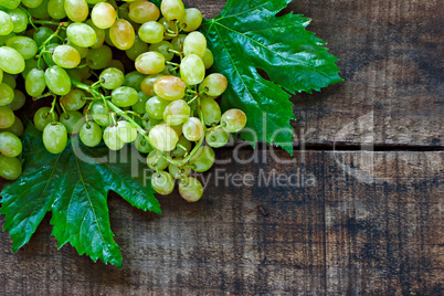 Green grapes on a rustic wooden table
