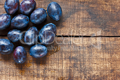 Fresh plums on old wooden table