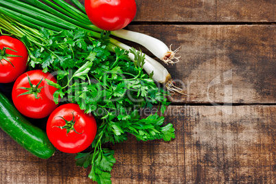 Tomatoes, cucumber, coriander and spring onions on old wooden ta