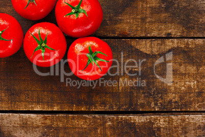 Ripe red tomatoes on rustic wooden background