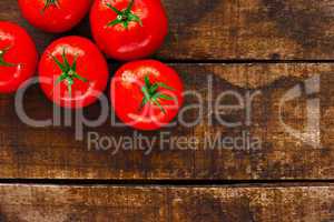Ripe red tomatoes on rustic wooden background