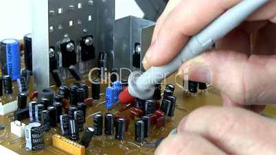 Technician probes circuit board; 2