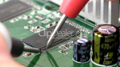 Technician probes circuit board; 3