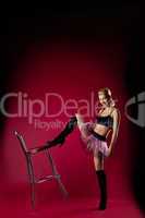 young woman in dance sport costume kick chair