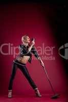 Beauty singer in black leather on red with mic