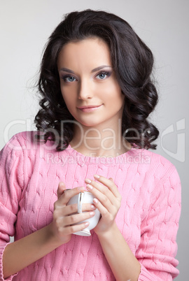 woman in rose jacket with cup of tea