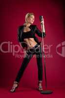 Beauty singer in black leather on red with mic