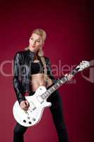 rock woman in black leather posing whit guitar