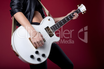 rock woman in black leather posing with guitar