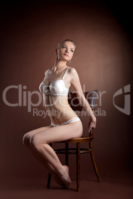 sexy woman portrait in white bra sit on chair