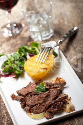 Steak in Scheiben auf einem Teller mit Salat