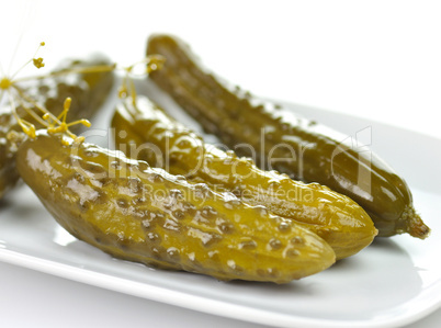 dill pickles on a white dish